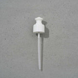 White plastic reusable pump on a gray background. To be used with Soothe, Hydrate, and Remove.