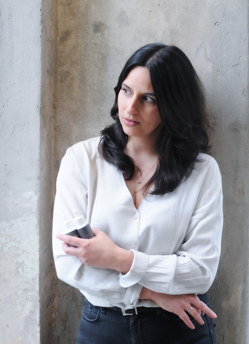 Kristina Dunn in a gray shirt leaning against a concrete wall