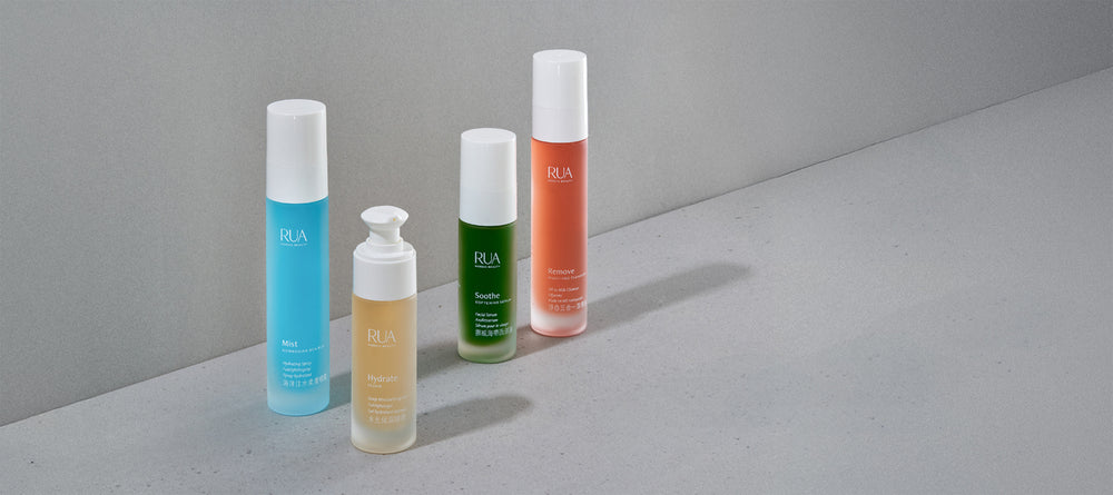 RUA Nordic Beauty skincare collection featuring four colorful bottles — Mist, Hydrate, Soothe, and Remove — displayed on a minimal grey surface with natural light.