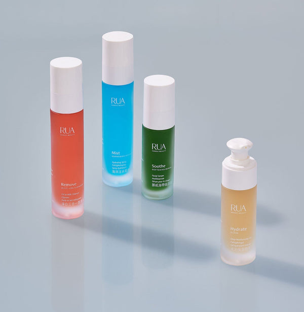 RUA Nordic Beauty skincare collection featuring four colorful bottles — Mist, Hydrate, Soothe, and Remove — displayed on a minimal grey surface with natural light.